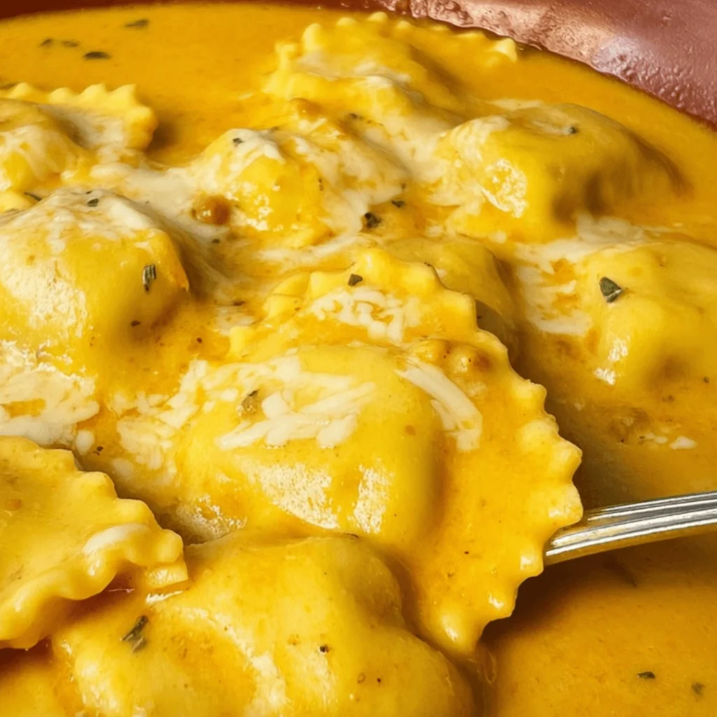 Creamy pumpkin and sage sauce over ravioli, garnished with Parmesan and fresh sage