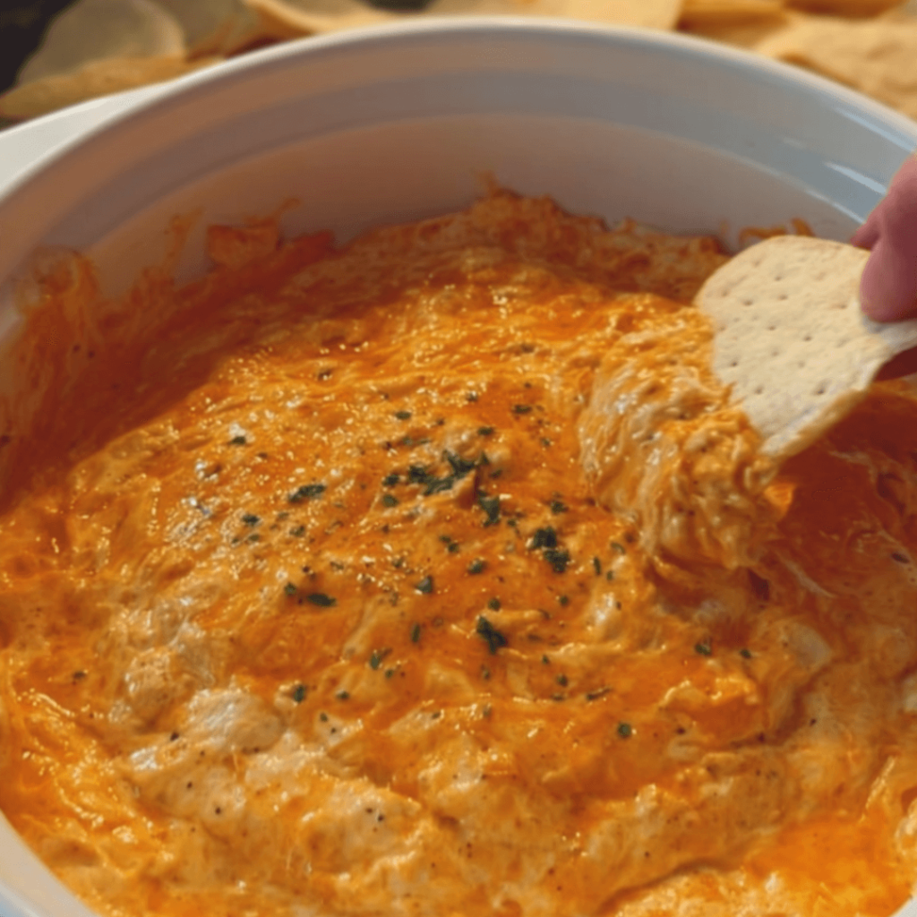 5 ingredient crockpot buffalo chicken dip in a slow cooker with chips on the side