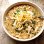 Creamy white chicken chili in a bowl topped with cheese and cilantro